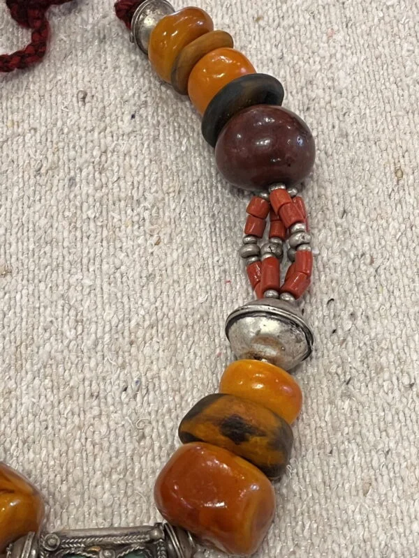 This Moroccan amber necklace is made of old amber, coral, silver beads and  old Berber traditional enameled silver cross of south