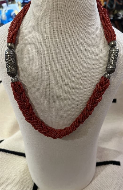 The red coral necklace is a stunning piece featuring an arrangement of 14 strands of coral beads