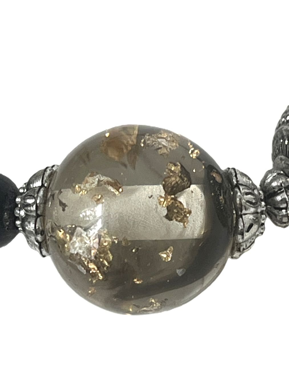 pierres translucides aux tons noirs et dorés, et des perles noires.