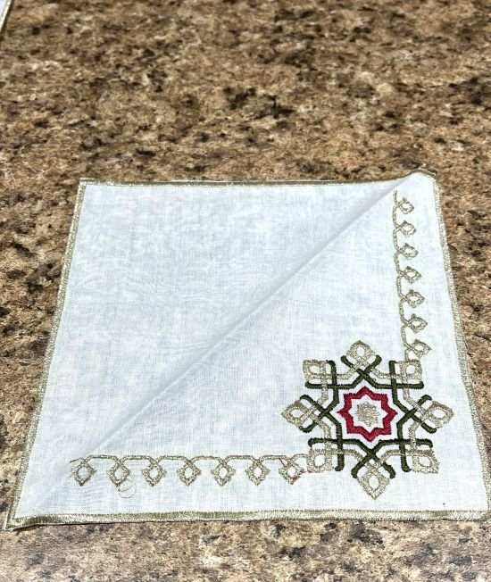 un des 6 napkins que comporte le set : nape pour plateau avec napkins, main theiere et base avec broderies de couleur argent,rouge et vert