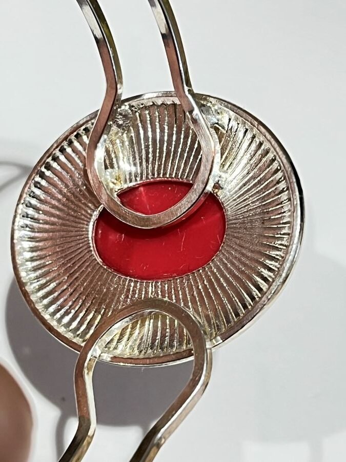 this silver-tone cuff bracelet showcases an oval deep red stone