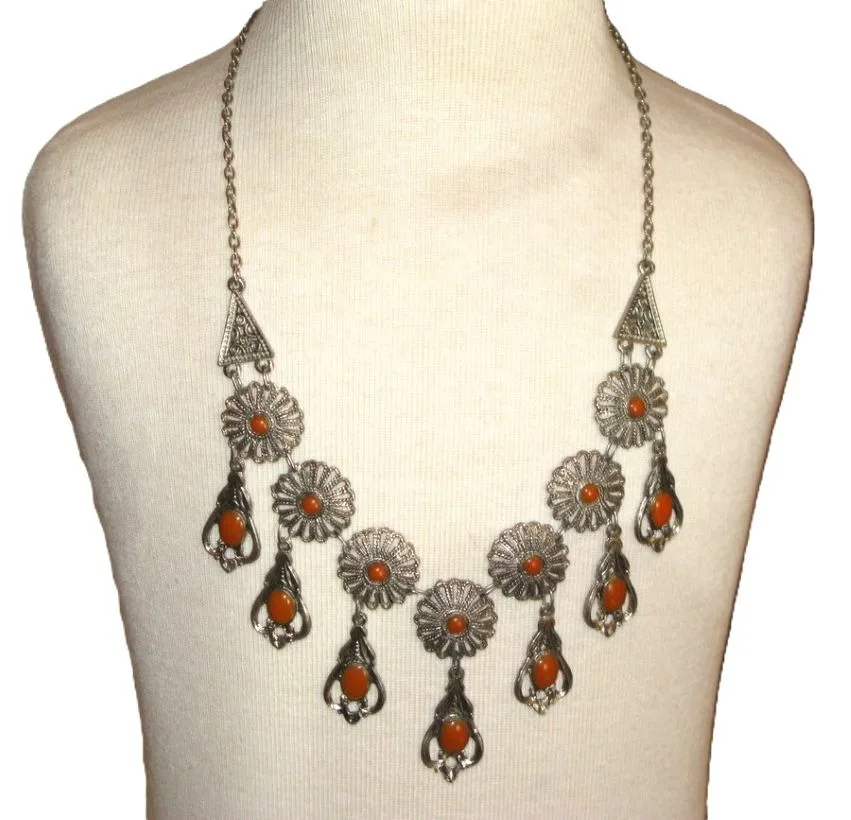 Ce collier de style vintage présente une ornementation en métal argenté
