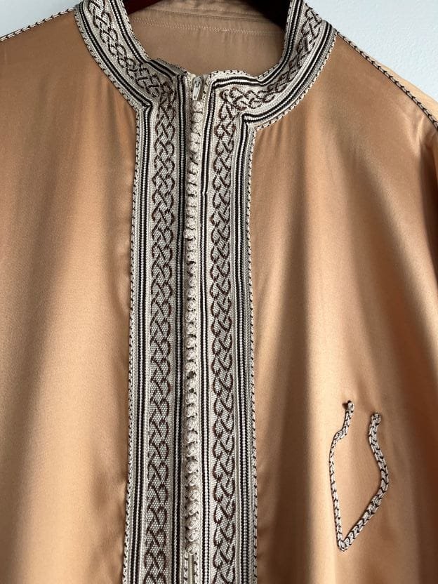 caftan orné de fines bordures tissées traditionnelles qui embellissent le col, le devant, les poignets, les poches