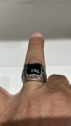 Bagues homme artisanales imposantes avec pierres noires à facettes, monture argentée et côtés gravés.