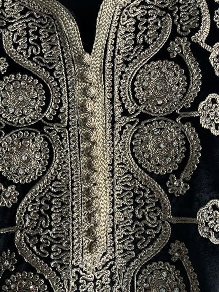 velours noir profond et des broderies dorées de caftan